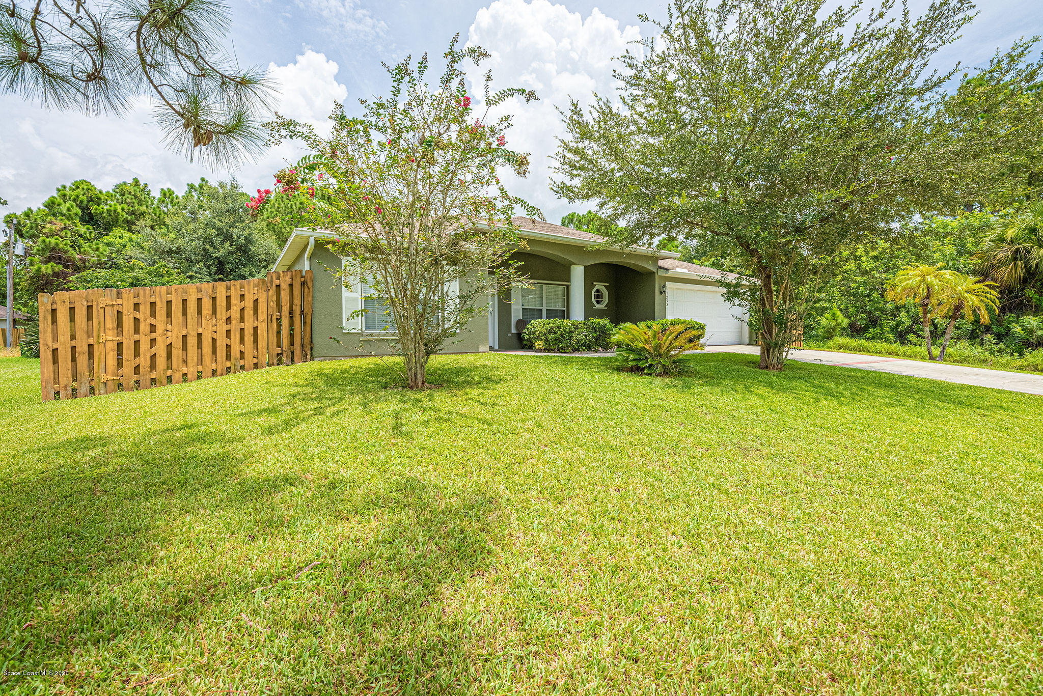 1253 Haulover Road Southwest Palm Bay, FL 32908 - Photo 5 of 52 a view of a house with a big yard and large trees