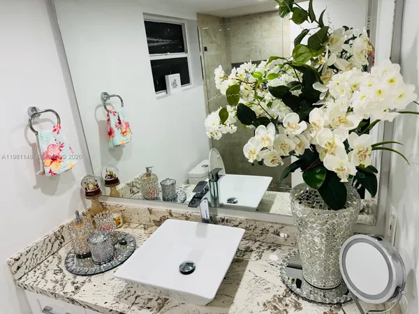 a bathroom with a sink mirror and toilet