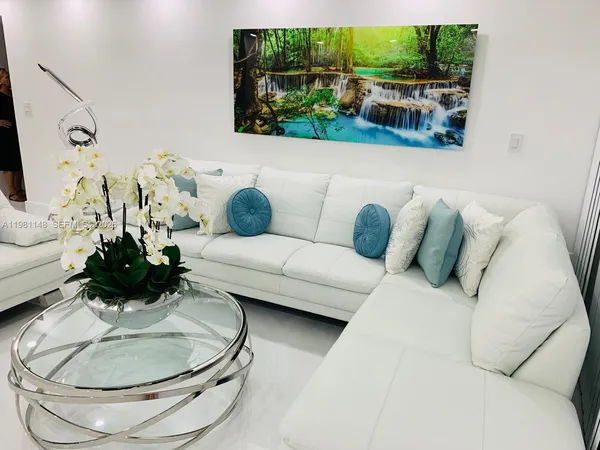 a living room with furniture and a floor to ceiling window