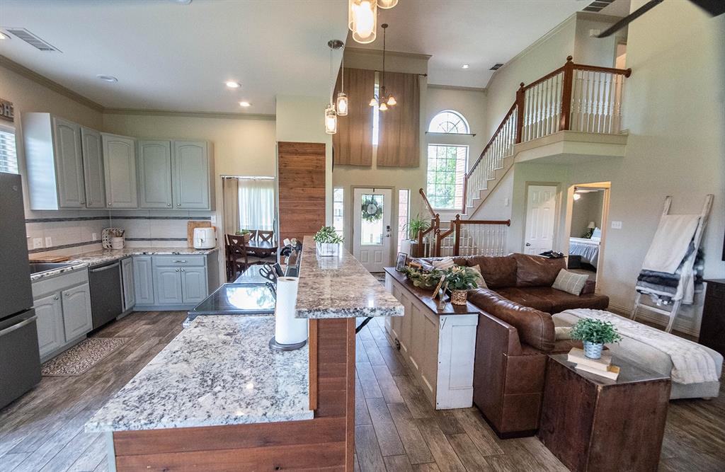 10336 Jennifer Circle Forney, TX 75126 - Photo 11 of 37 A cross-section photograph, taken from the end of a room, reveals a seamless blend of home life, featuring a modern, fully equipped kitchen on one side and a cozy, inviting living area on the other.