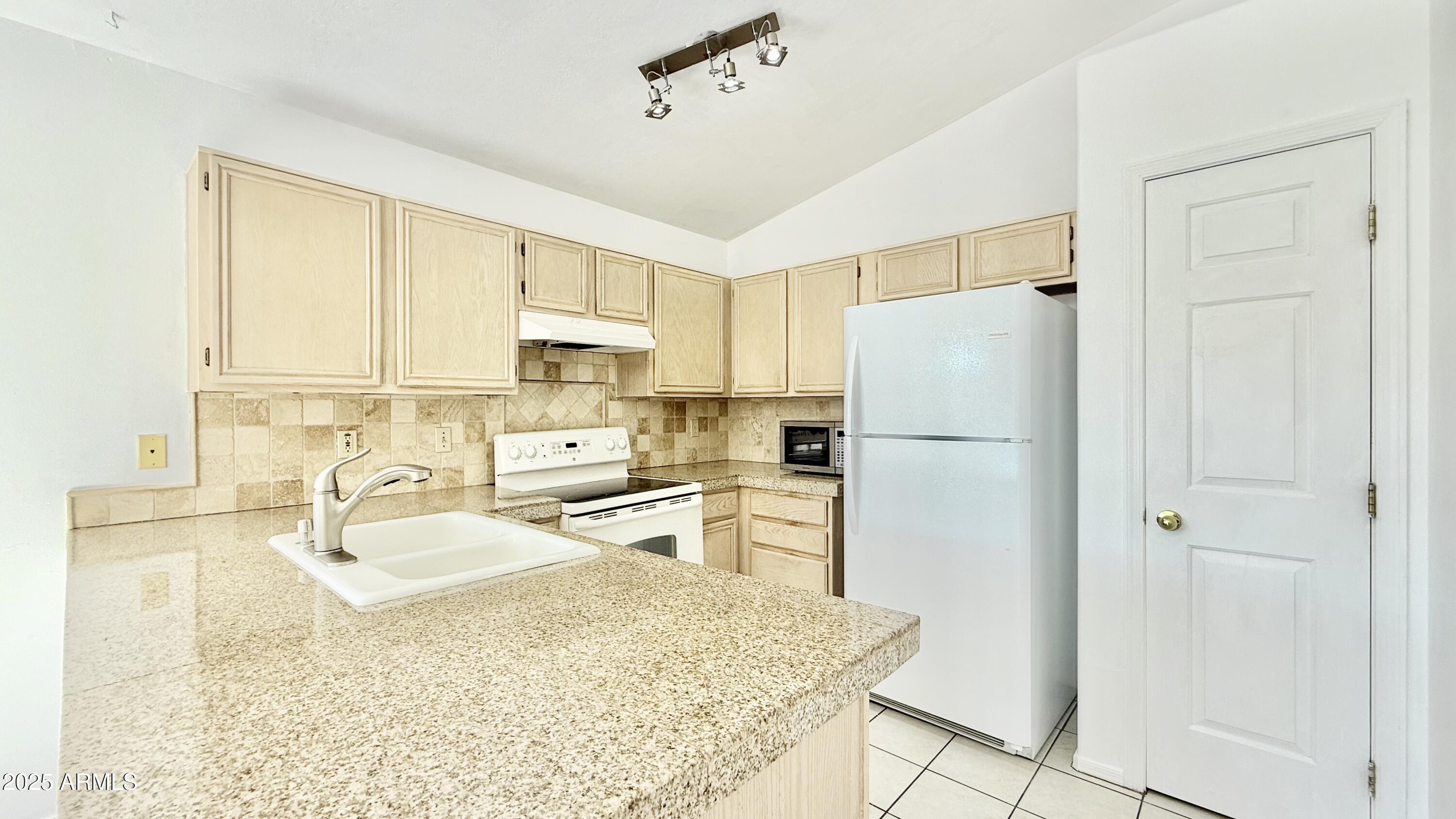 413 North Flint Street Gilbert, AZ 85234 - Photo 4 of 19 a kitchen with a refrigerator a stove a sink dishwasher and white cabinets with wooden floor