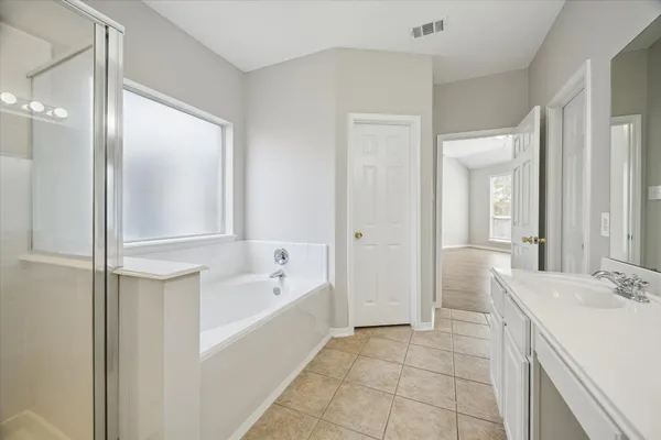 a bathroom with a tub sink and mirror