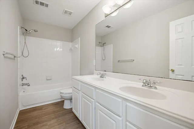 a bathroom with a granite countertop sink a toilet and shower