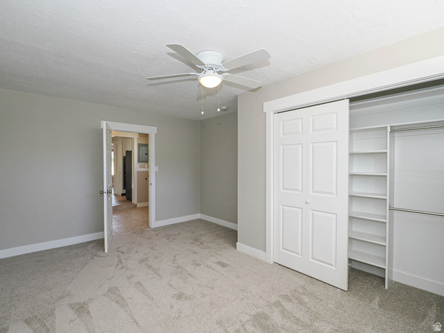 154 East 3000th Street South Bountiful, UT 84010 - Photo 22 of 37 Neutral-toned carpeted room featuring a ceiling fan with integrated lighting, a sliding closet with built-in shelving, and a white paneled door