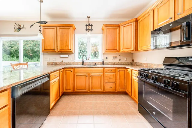 a kitchen with stainless steel appliances granite countertop a sink a stove and a refrigerator