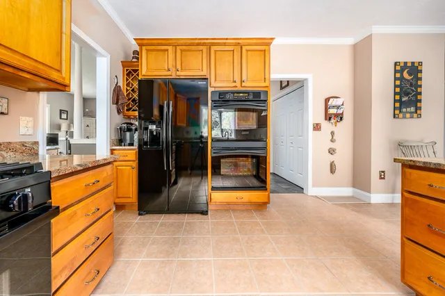 a kitchen with stainless steel appliances granite countertop a refrigerator and a stove