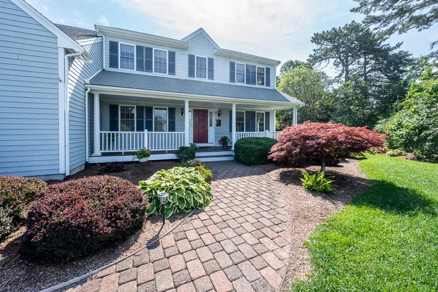 a front view of a house with a yard and potted plants