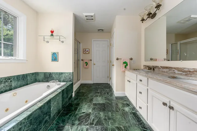 a bathroom with a tub sink and mirror