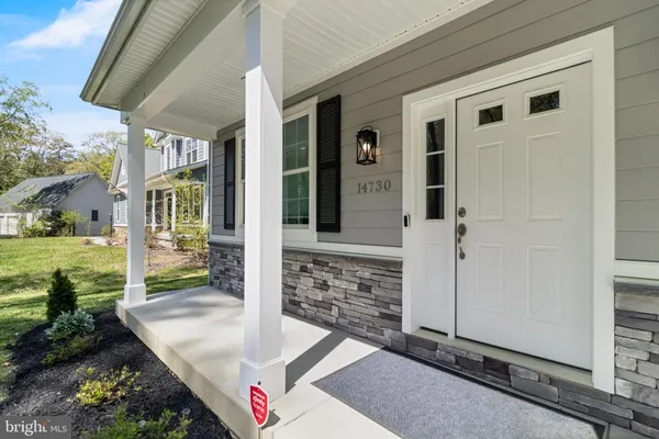 a view of center island of a kitchen with granite countertop living room and stainless steel appliances