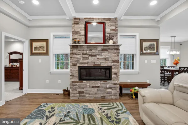 a kitchen with stainless steel appliances kitchen island granite countertop a table chairs in it and wooden floors