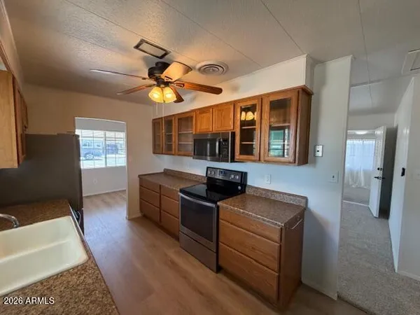 a kitchen with stainless steel appliances granite countertop a sink and wooden floors