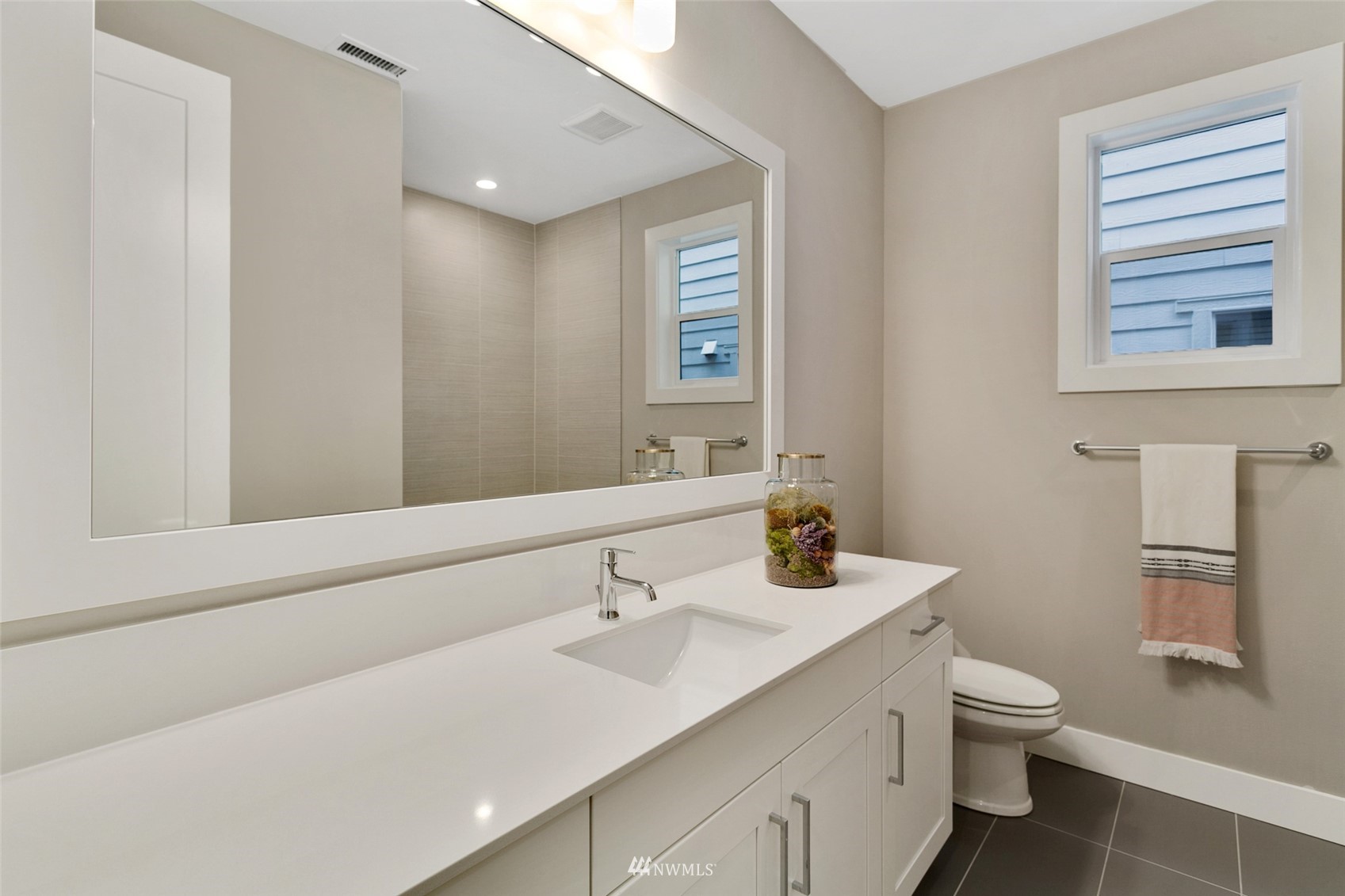 21899 Southeast 5th Place Sammamish, WA 98074 - Photo 27 of 35 a bathroom with a toilet a sink a mirror and a window