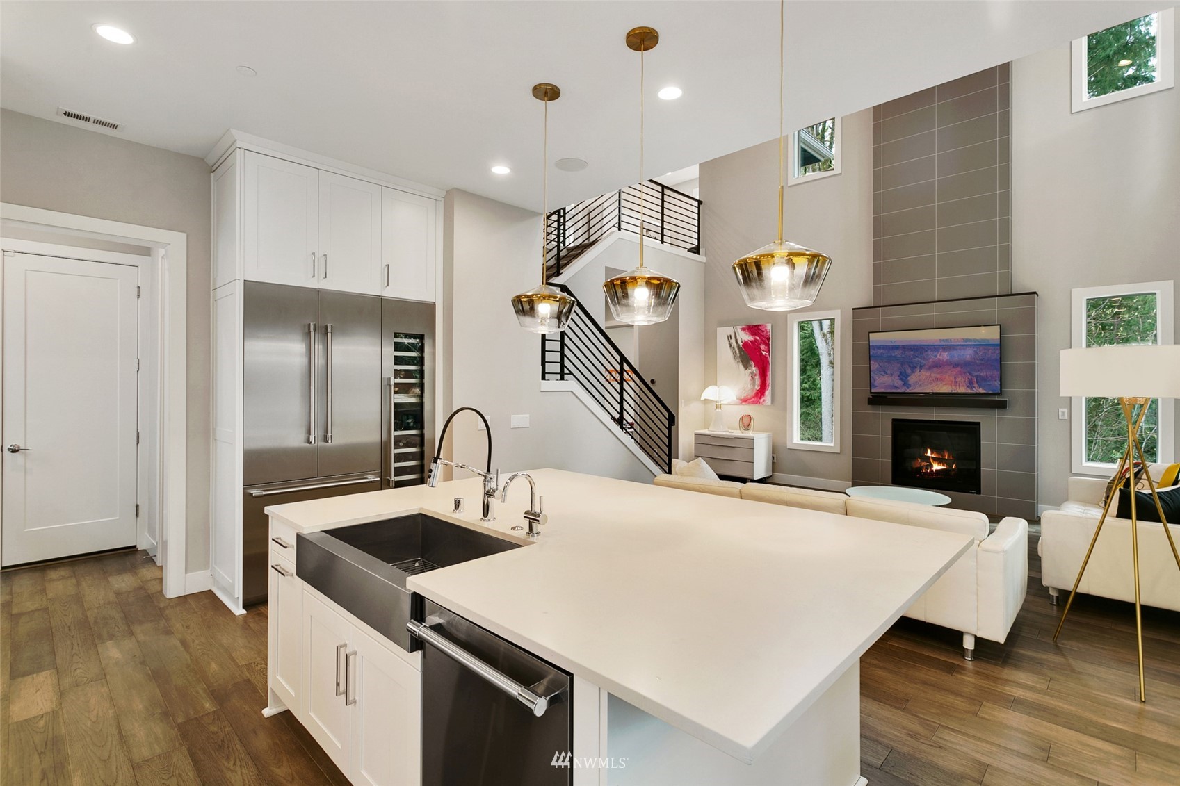 21899 Southeast 5th Place Sammamish, WA 98074 - Photo 8 of 35 a kitchen with stainless steel appliances kitchen island a table and a fireplace