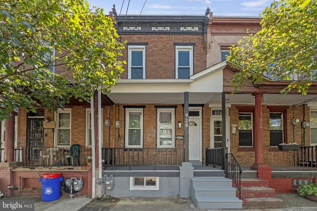 a front view of a house with a tree