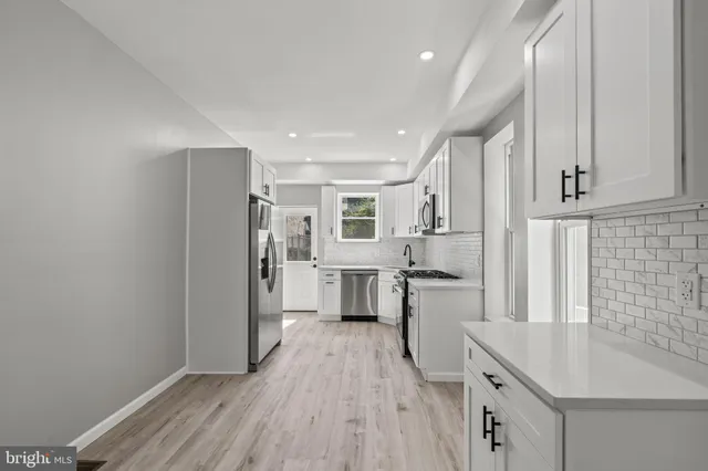 a kitchen with white cabinets and stainless steel appliances