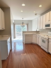 10049 Cummings Street Huntley, IL 60142 - Photo 10 of 30 a kitchen with stainless steel appliances granite countertop a stove top oven a sink dishwasher and white cabinets with wooden floor