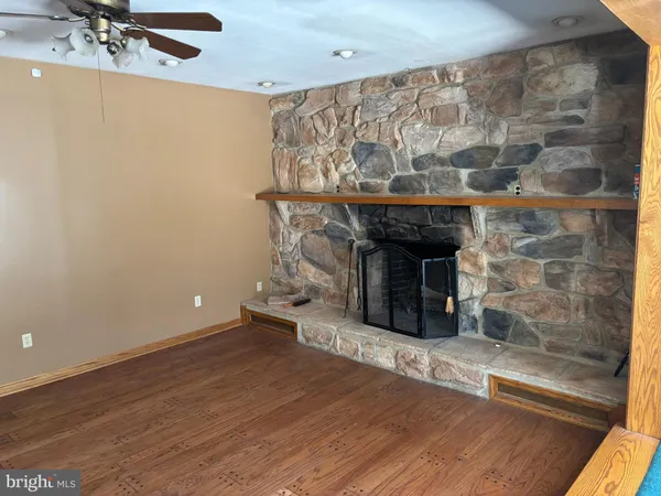 a room with a fireplace and a wooden floor