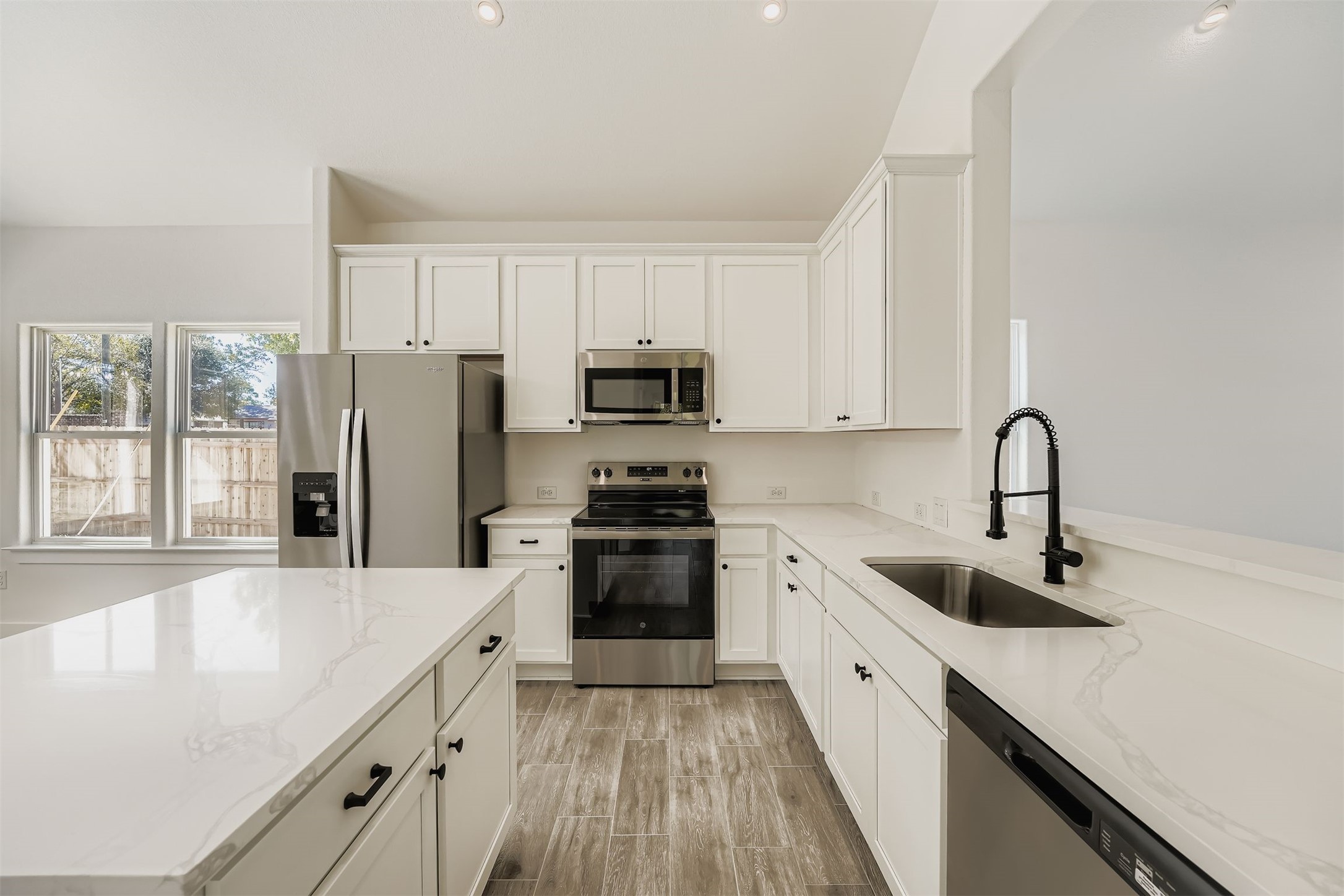 701 East 3rd Street Elgin, TX 78621 - Photo 12 of 28 a kitchen with a refrigerator a sink a stove and cabinets