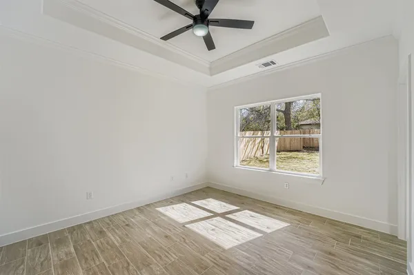 an empty room with a window and a ceiling fan