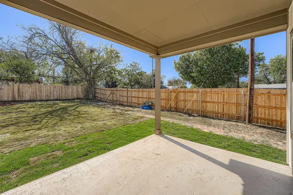 a view of a backyard with wooden fence