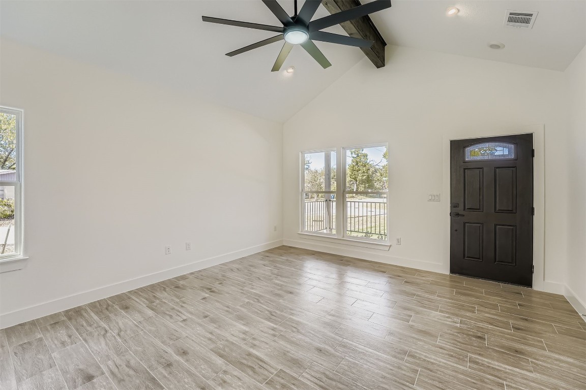 701 East 3rd Street Elgin, TX 78621 - Photo 5 of 28 Bright living room with large windows, vaulted ceiling, and ceiling fan