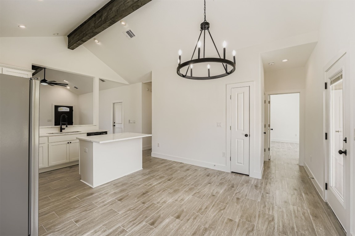 701 East 3rd Street Elgin, TX 78621 - Photo 9 of 28 Kitchen with a center island, beamed ceiling, white cabinetry, and ceiling fan