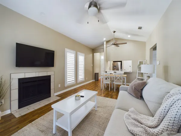a living room with furniture a fireplace and a flat screen tv