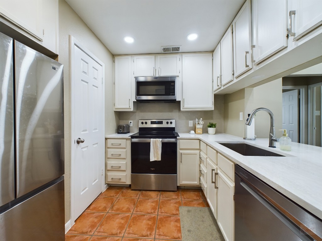 711 West 21st Street, Unit 304 Austin, TX 78701 - Photo 2 of 13 a kitchen with stainless steel appliances a refrigerator sink and stove