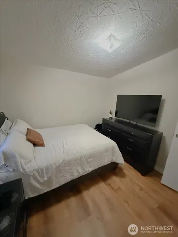 a living room with a bed furniture and a flat screen tv
