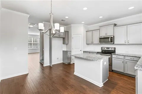 a kitchen with stainless steel appliances granite countertop a refrigerator a stove top oven a sink and dishwasher