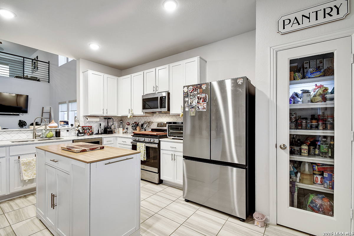 8863 Grey Elm Elmendorf, TX 78112 - Photo 11 of 35 a kitchen with stainless steel appliances a refrigerator stove microwave and sink