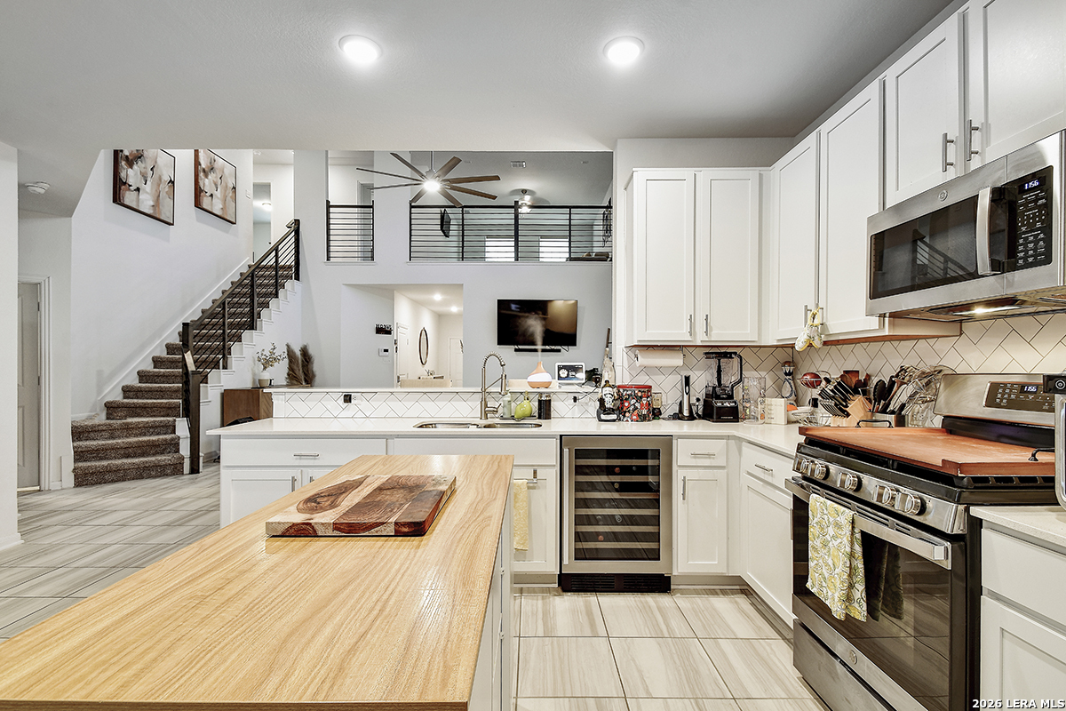 8863 Grey Elm Elmendorf, TX 78112 - Photo 12 of 35 a kitchen with stainless steel appliances a stove microwave and cabinets