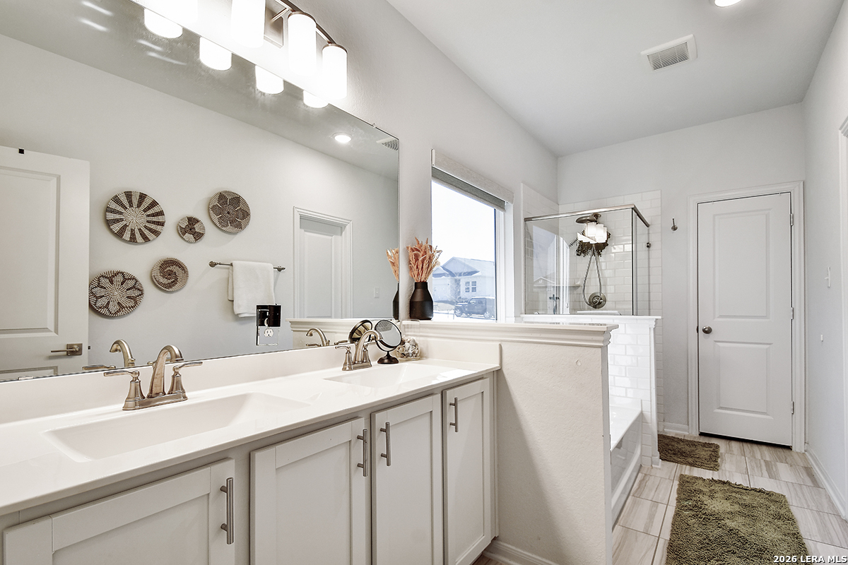 8863 Grey Elm Elmendorf, TX 78112 - Photo 21 of 35 a bathroom with a sink double vanity and a mirror