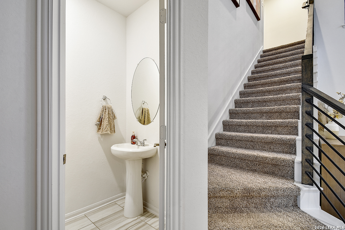 8863 Grey Elm Elmendorf, TX 78112 - Photo 23 of 35 a bathroom with a sink and mirror