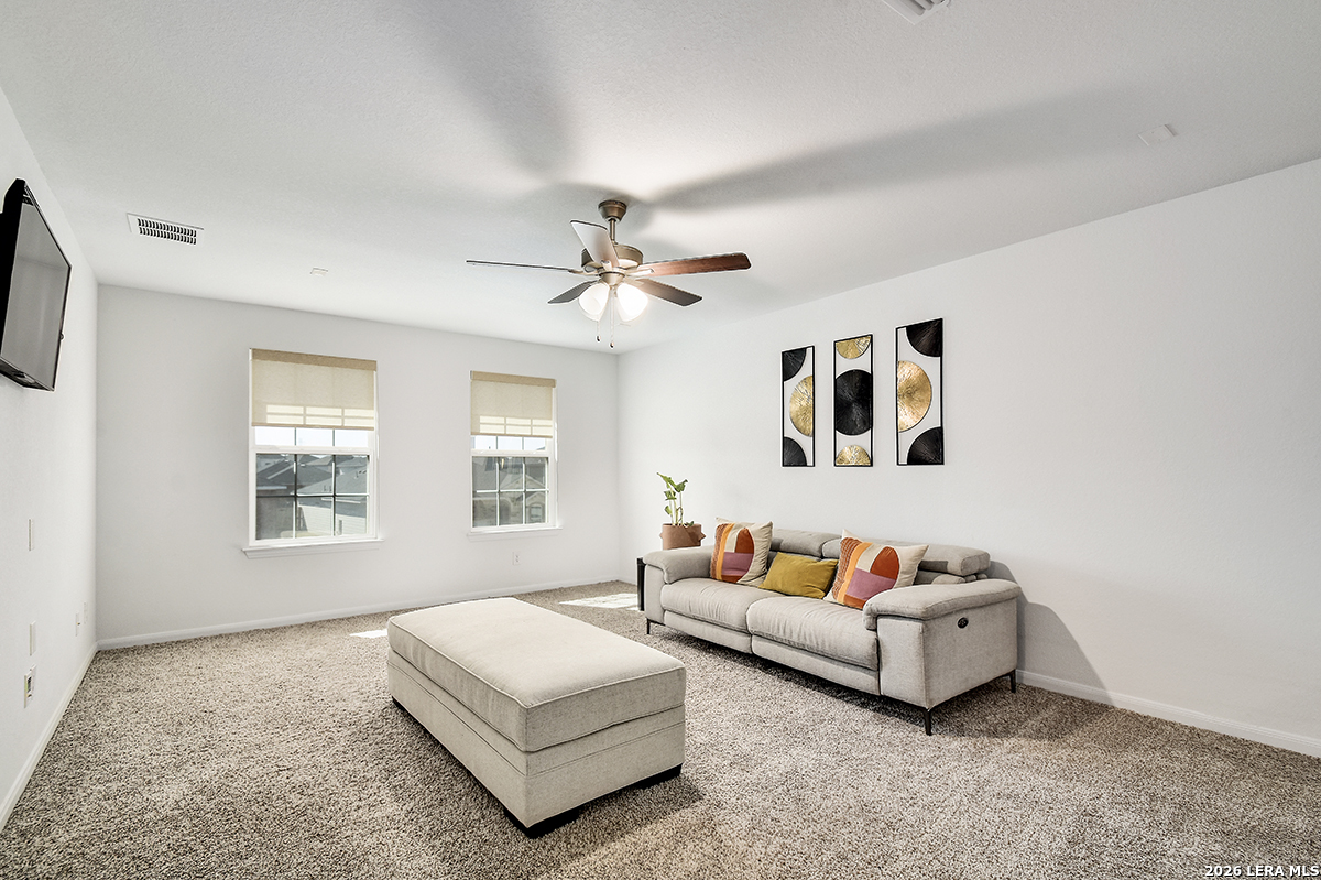 8863 Grey Elm Elmendorf, TX 78112 - Photo 25 of 35 a spacious bedroom with a bed furniture and window
