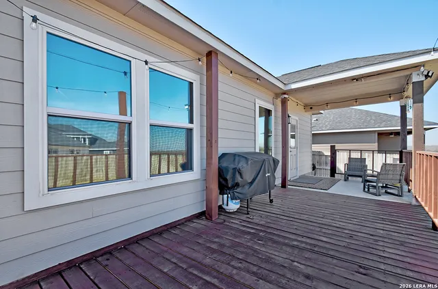 a view of a house with wooden deck and furniture