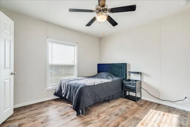 a bedroom with a bed and a ceiling fan