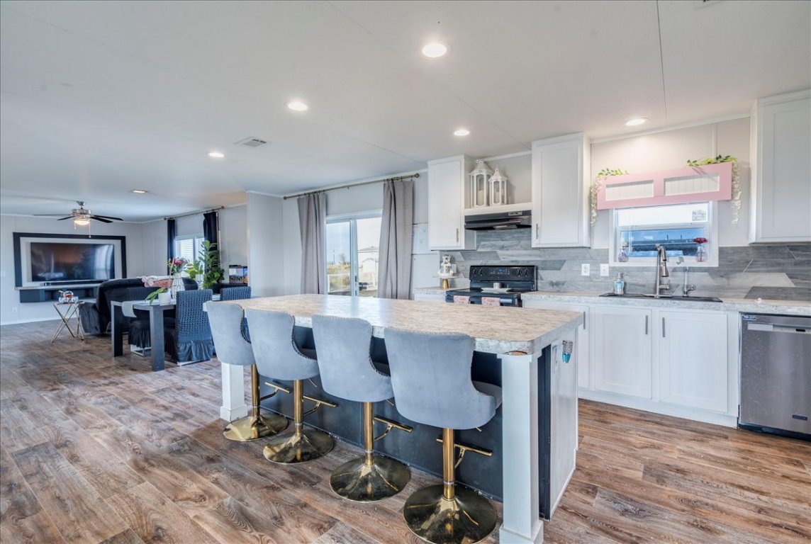 114 Gran Cielo Elgin, TX 78621 - Photo 6 of 40 a kitchen with stainless steel appliances kitchen island granite countertop a sink and cabinets