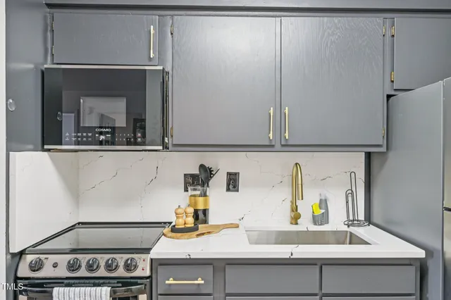 a kitchen with a sink and a stove with cabinets