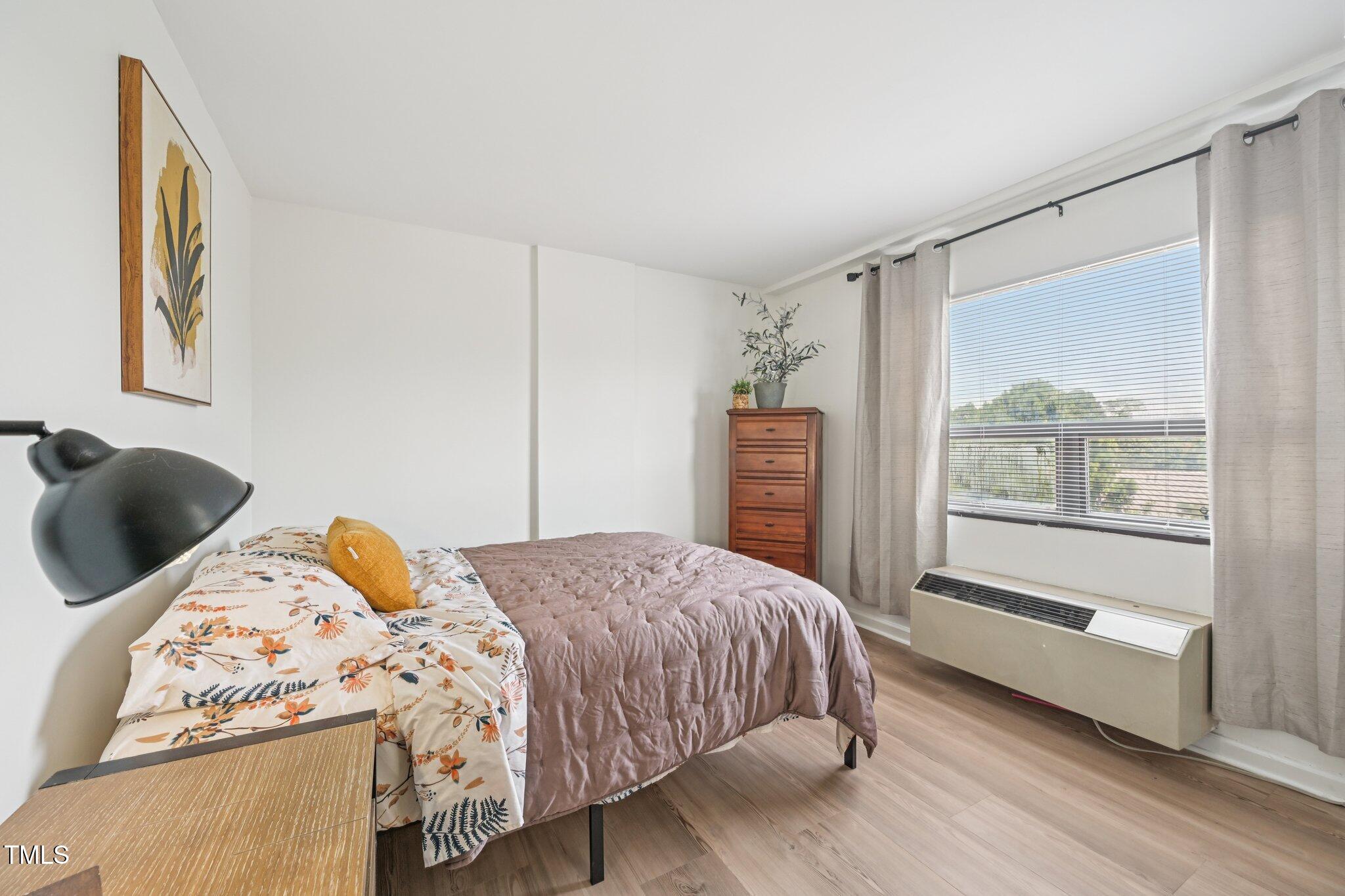 4700 Westgrove Street, Unit 721 Raleigh, NC 27606 - Photo 19 of 21 a bedroom with a bed and wooden floor