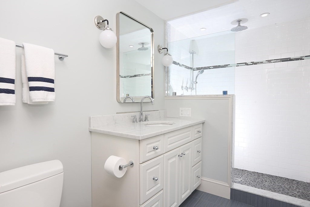 16 Pilgrim Road Newton, MA 02468 - Photo 17 of 25 a bathroom with a granite countertop sink a toilet and a mirror