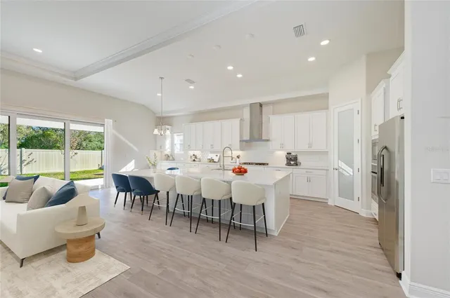 a large kitchen with lots of furniture a sink appliances and a dining table