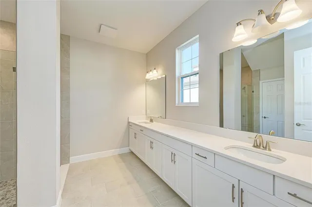 a spacious bathroom with a double vanity sink mirror and next to a window