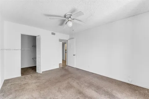 an empty room with a ceiling fan and a window