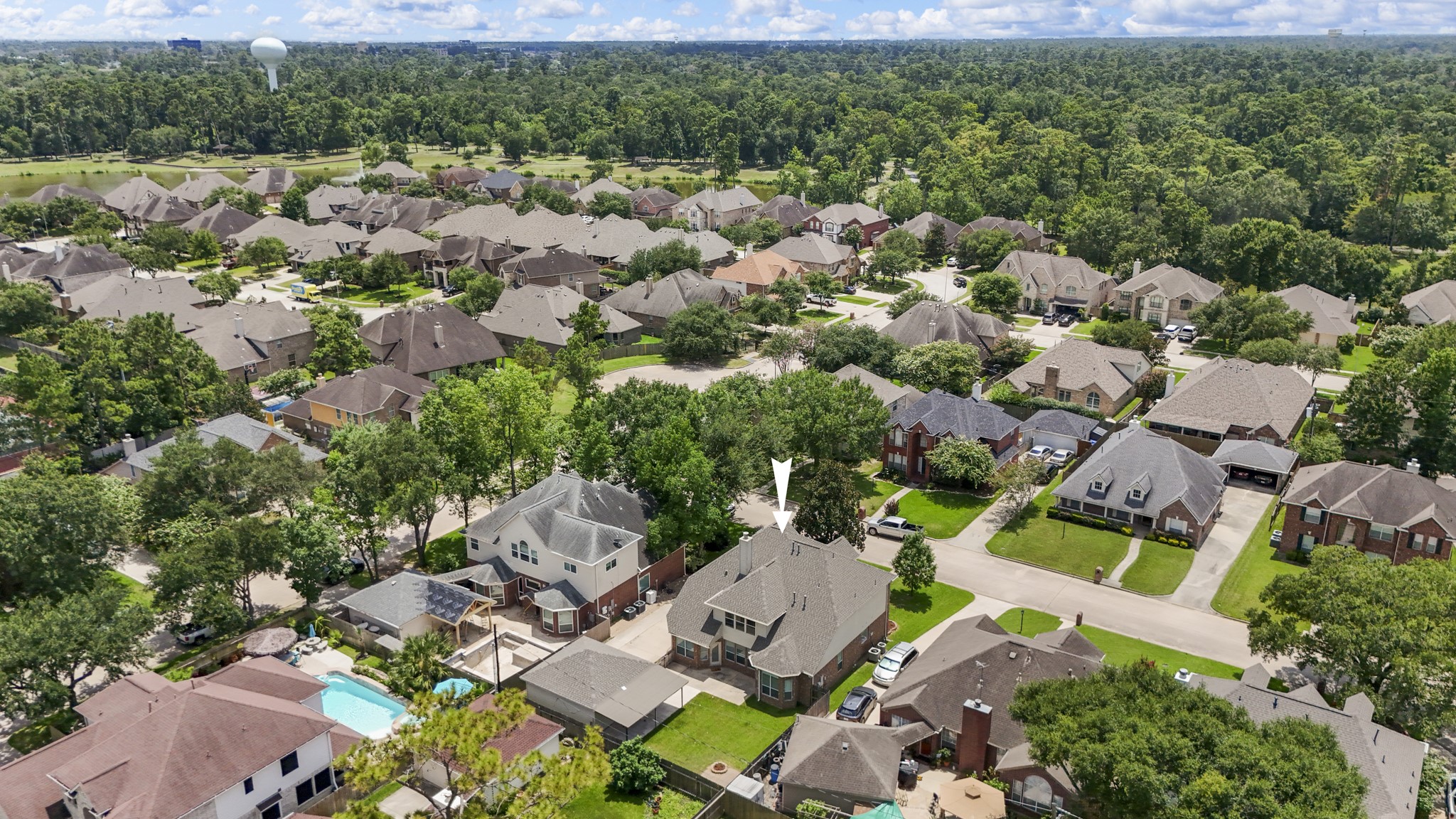 19106 South Rim Trail Spring, TX 77388 - Photo 2 of 50 Zooming out, the Cypress Forest setting comes into view, with established streets, surrounding greenery, and neighborhood rooftops stretching beyond the home. This perspective helps buyers understand the broader location — a cul-de-sac community feel with nearby everyday conveniences, plus the option for Cypress Forest residents to join Forest Oaks Swim and Racquet Club for swimming, tennis, fitness, clubhouse amenities, and social events just minutes away.