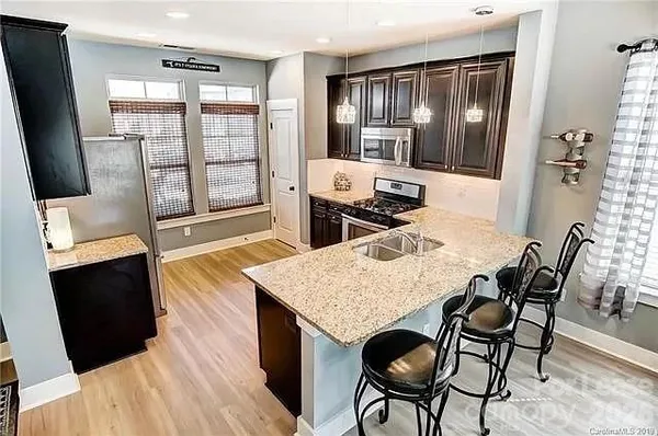a living room with furniture a rug a flat screen tv and floor to ceiling window