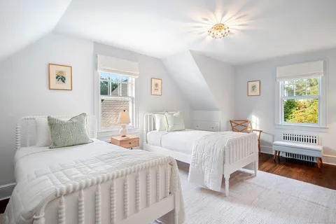 a bedroom with two beds and a chandelier