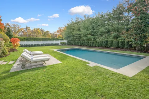 a view of a swimming pool with a patio and a yard