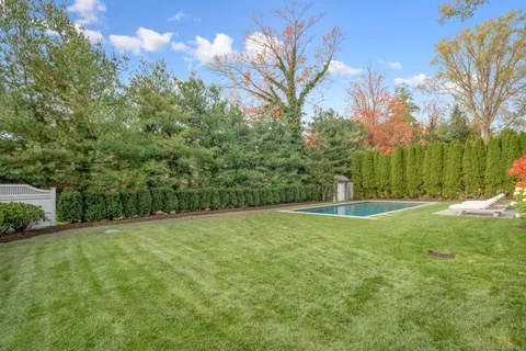 a view of a grassy field with trees in the background