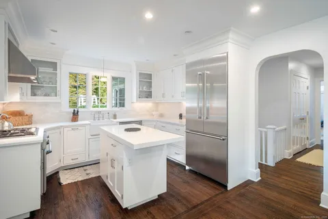 a kitchen with white cabinets and white appliances